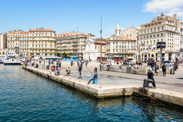 The quai des Belges seen from the basin of the Old Port of Marseille, France. Marseille, France - May 18, 2018: The quai des Belges seen from the basin of the Old Port, one of the busiest place in the city, with the metro station and the church of Saint-Ferréol les Augustins. marseille station stock pictures, royalty-free photos & images