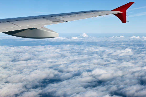 istock View from the airplane at the wing, white clouds and blue sky. 1080795464