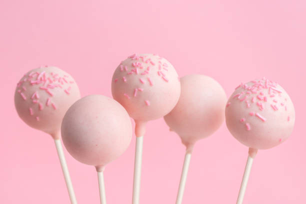 istock festive icing cake pops over pink background, close up 1080795656