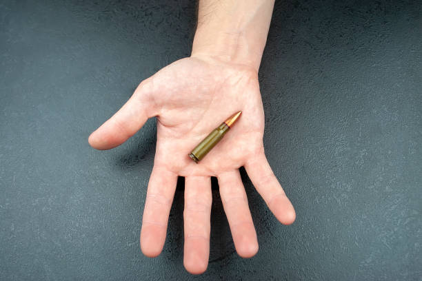 人間の手で横になっているカラシニコフ突撃銃用の緑の 7.62 mm カートリッジ - armed forces human hand rifle bullet ストックフォトと画像