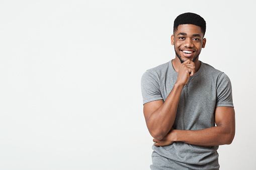 Interesado sonriente hombre afroamericano tocando barbilla, espacio de copia photo