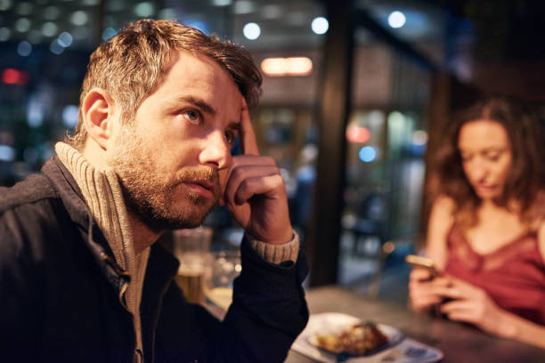 We don't talk much these days Cropped shot of a frustrated boyfriend being ignored by his girlfriend while she is using a cellphone at a nightclub vex nightclub stock pictures, royalty-free photos & images