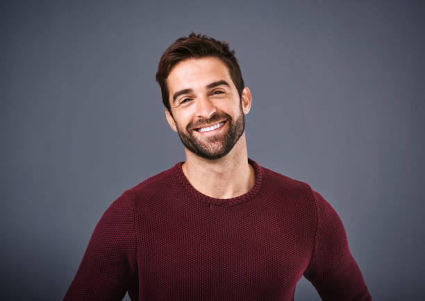 My confidence comes naturally Studio shot of a handsome and happy young man posing against a gray background charming stock pictures, royalty-free photos & images