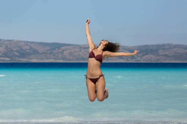 istock Young woman jumps on the beach 1080821500