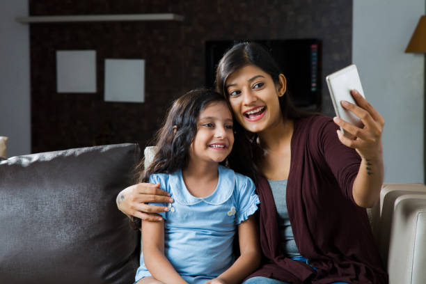 istock Mother And Daughter Sit On Sofa - Stock image 1080826994