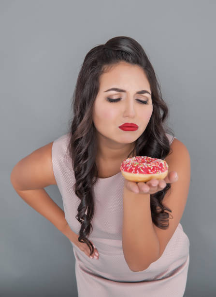 istock Beautiful sad plus size woman with donut 1080827320