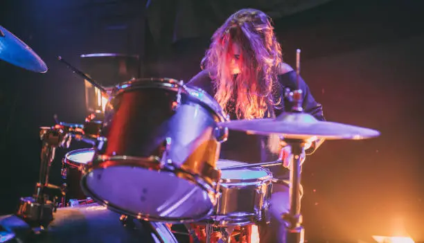 One woman, beautiful woman playing drums on stage.