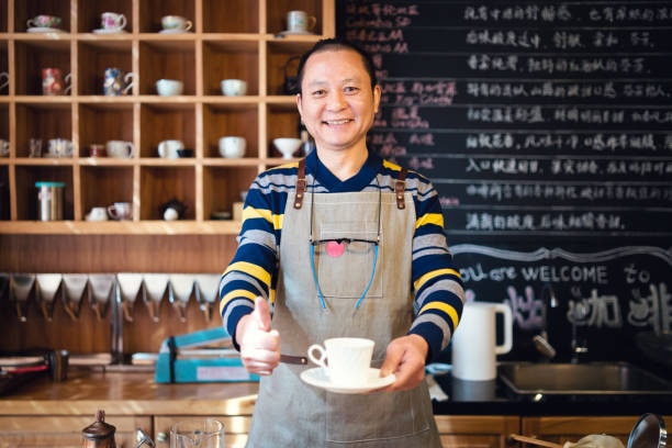 Confident coffee shop owner with a cup of freshly made coffee.