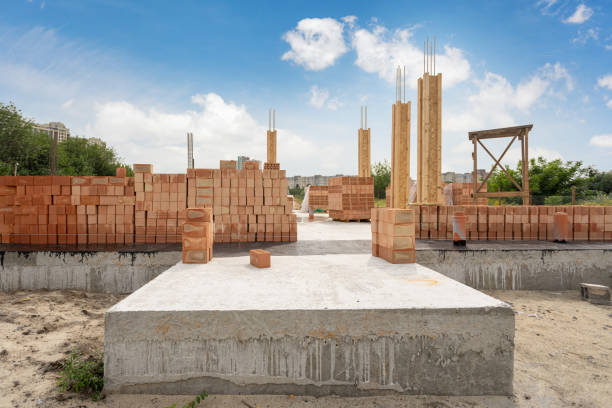 House under construction. New residential building with support element and brick wall on foundation