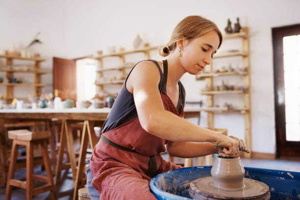 From clay to fancy! Shot of a woman molding clay on a pottery wheel earthenware stock pictures, royalty-free photos & images