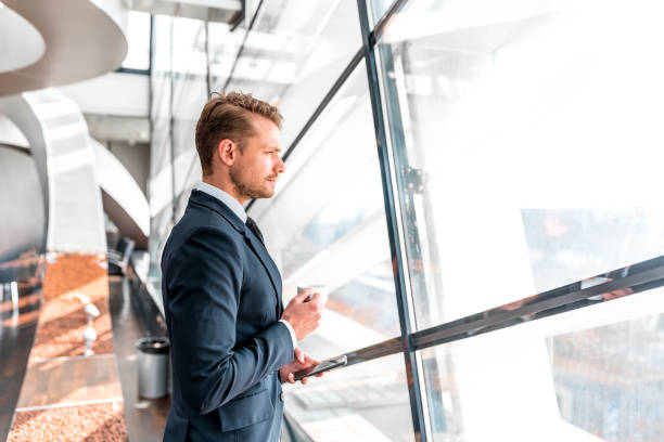 istock Businessman standing by the window and holding a coffee cup 1080862090