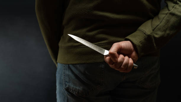 istock Criminal with knife weapon hidden behind his back 1080865626