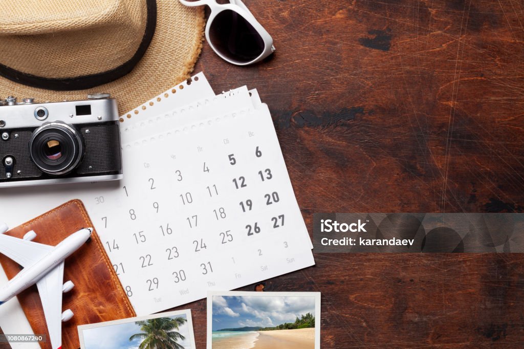 Travel vacation concept Travel vacation background concept with calendar, sun hat, camera, passport, airplane toy and weekend photos on wooden backdrop. Top view with copy space. Flat lay. All photos taken by me Vacations Stock Photo