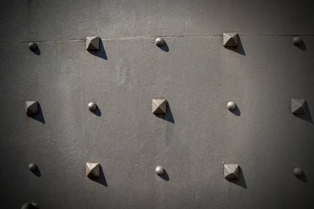 Metal Door with Pyramidal Studs - Background Detail of an old metal door with studs in the shape of a pyramid, background metal stud stock pictures, royalty-free photos & images