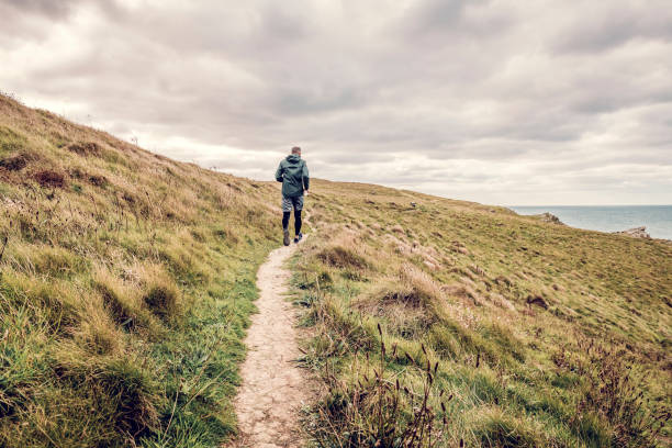 istock Man trail running along the rugged Cornish coastline on an Autumn day. 1080872566