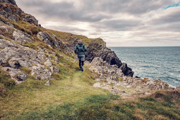 istock Man trail running along the rugged Cornish coastline on an Autumn day. 1080872628