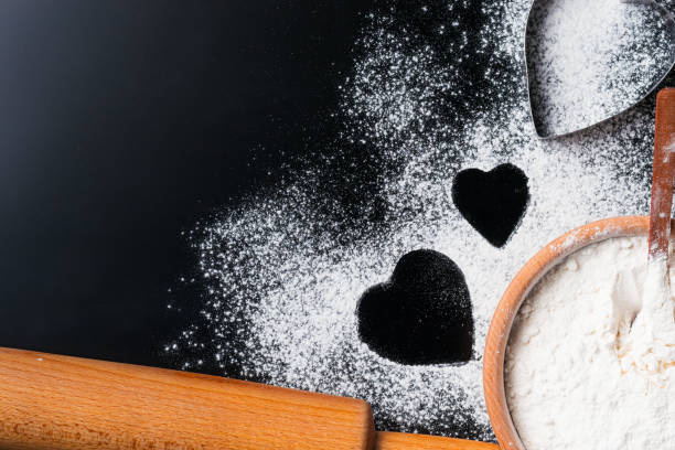 istock Baking background with flour, rolling pin and heart shape on a dark table with copy space, top view, flat lay. Valentines day cooking concept 1080875068