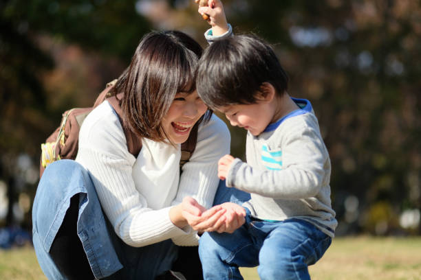 istock Mother and child playing in park 1080883012