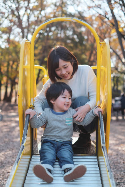istock Child playing on slide with mother 1080883354
