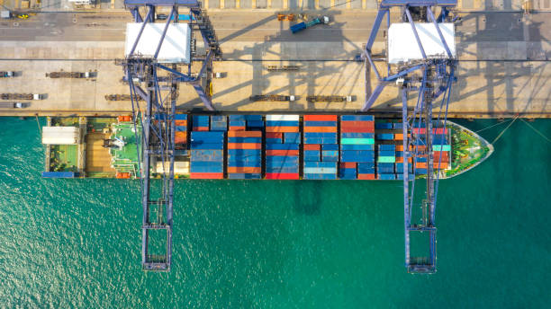 istock Container ship in export and import business and logistics. Shipping cargo to harbor by crane. Water transport International. Aerial view and top view. 1080886048