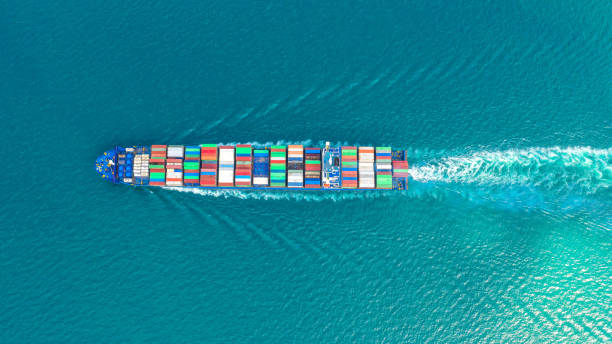 Container ship in export and import business and logistics. Shipping cargo to harbor by crane. Water transport International. Aerial view and top view.
