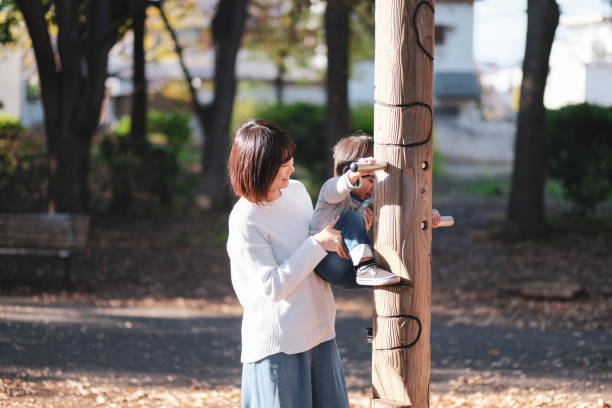 istock Mother helping child to play in park 1080886256