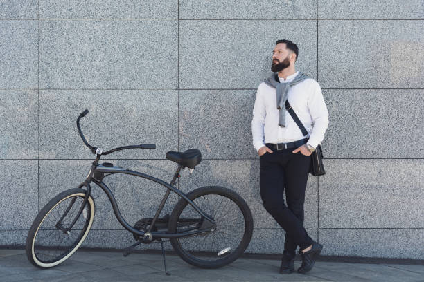 istock Businessman standing against building wall with his bicycle. 1080888250