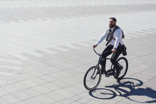 istock Businessman riding bicycle to workplace for protecting environment 1080888254