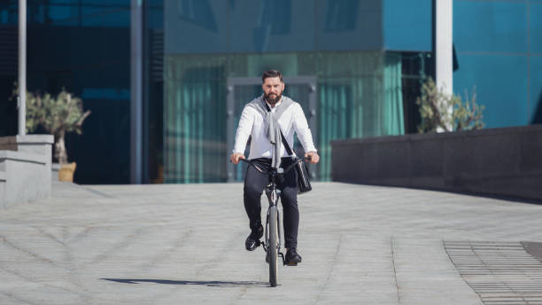 istock Active serious bearded businessman riding his bicycle 1080888258