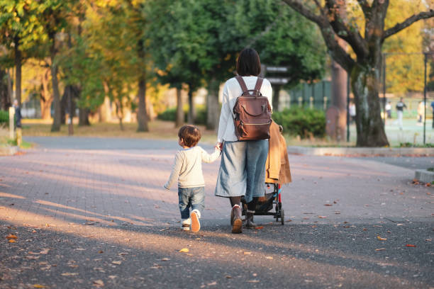 istock Mother and son walking in park with holding hands 1080888332
