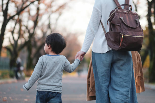 母と息子と手を繋いで公園を歩いて - 子ども　散歩 ストックフォトと画像