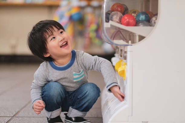 niño comprar juguete de máquina expendedora - vending machine fotos fotografías e imágenes de stock