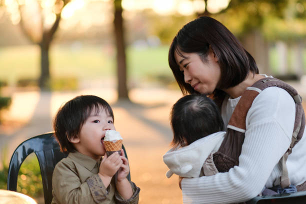 istock Child eating ice cream with mother 1080888918