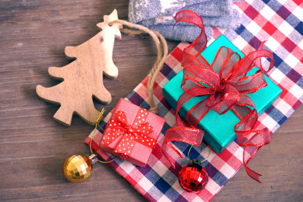 istock Green and red gift boxes and pine cone on the cloth with pine tree make from wood on the table 1080894562
