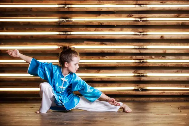 Photo of Pretty little girl in the room in sportswear for martial arts is Wushu