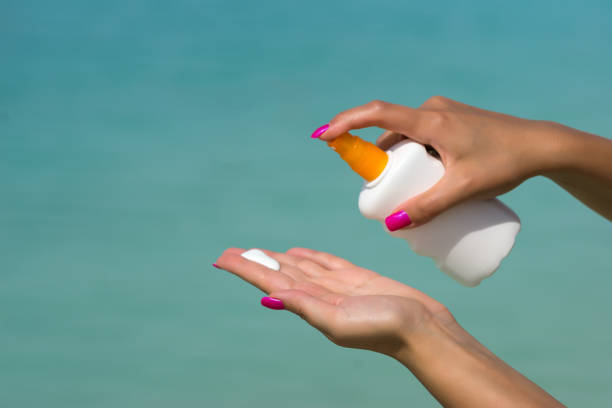 istock Woman hands putting sunscreen from a suncream bottle 1080903234