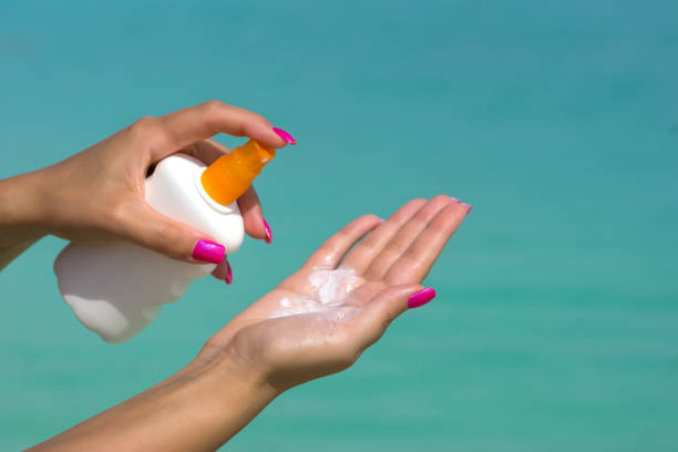 istock Woman hands putting sunscreen from a suncream bottle 1080903256