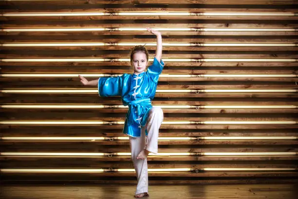 Photo of Pretty little girl in the room in sportswear for martial arts is Wushu