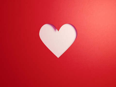 Red cut out heart shape on white background. Horizontal composition with  copy space.