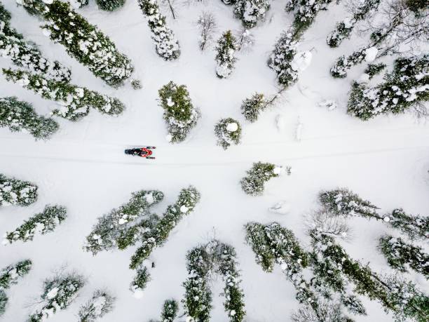 вид с воздуха на снегоход в снежный зимний день в сельской финляндии - snowmobiling adventure snow travel стоковые фото и изображения