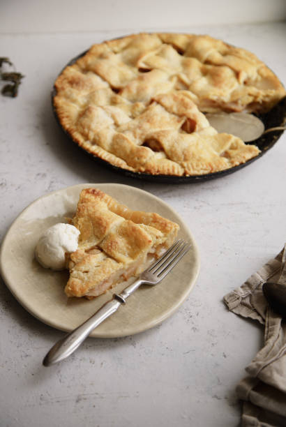 istock Apple pie with lattice decoration and a slice served on handmade ceramic plate with a scoop of vanilla ice-cream 1080949656