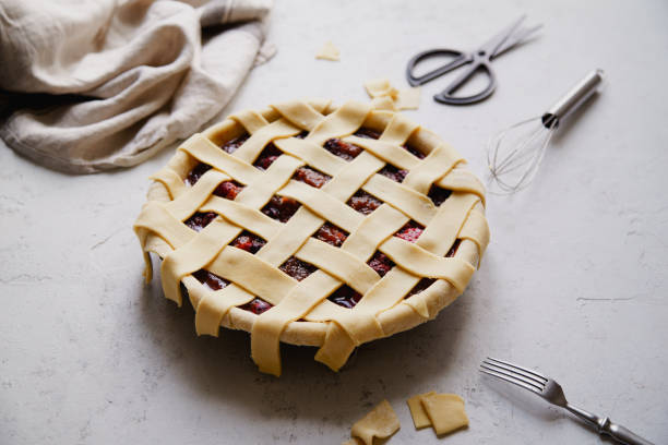 istock Uncooked berry pie with a lattice decoration on top. Concrete background, cooking process. 1080950612
