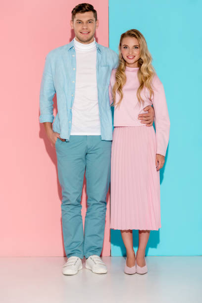 istock smiling couple looking at camera and posing on pink and blue background 1080951270