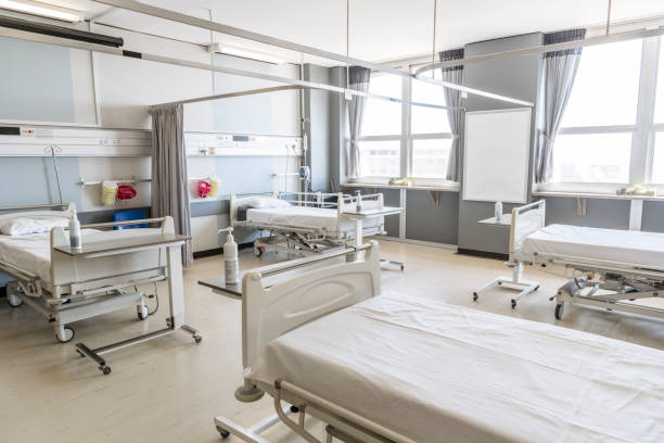 istock Hospital ward with four empty beds and open curtains 1080953198