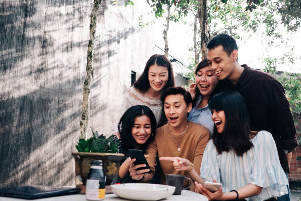 gruppe von jungen asiatischen leuten mit smartphone - teenager city life laughing group of people stock-fotos und bilder