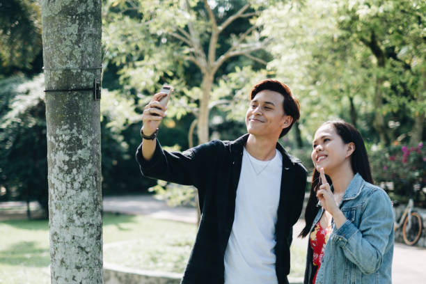 istock Young Asian Couple with Smartphone 1080960622