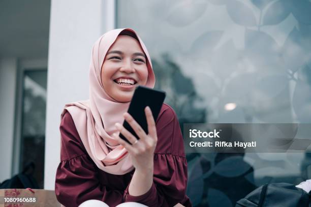 Young Asian Muslim Women Playing Smartphone Stock Photo - Download Image Now - Teenager, Islam, Malaysia