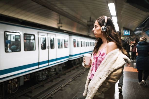 istock Young woman with headphones inside subway station platform 1080962602