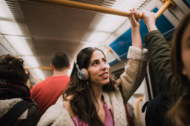 Young woman with headphones inside subway station platform