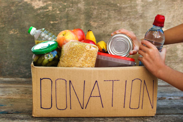 istock Donation box with food on old wooden background. 1080964254